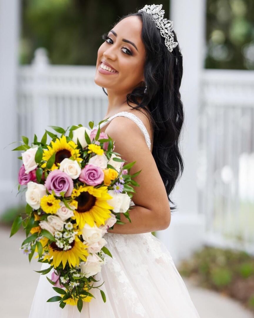 A Bride Holding a Bouquet With Sunflowers and Roses