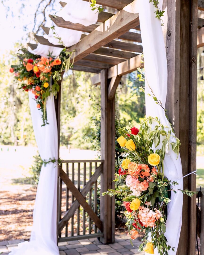 A Wooden Archway With Yellow and Peach Flowers