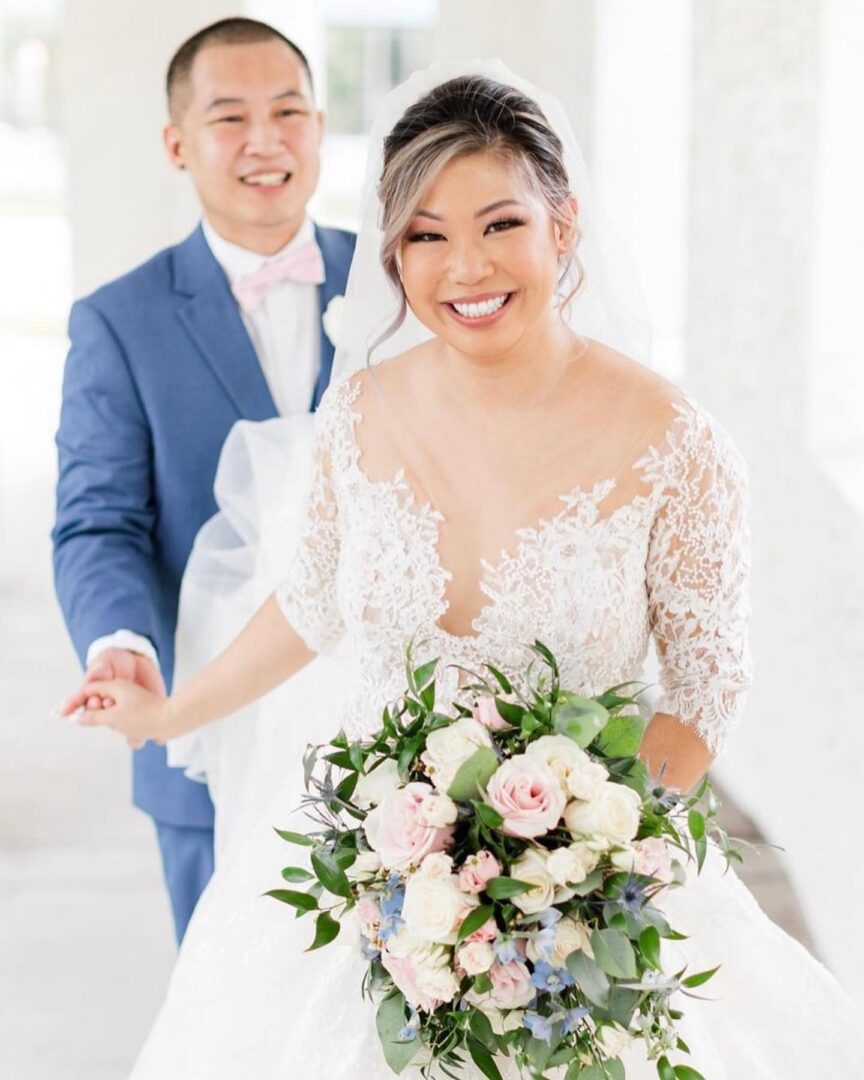 A Groom Standing Behind a Bride With a Flower Bunch