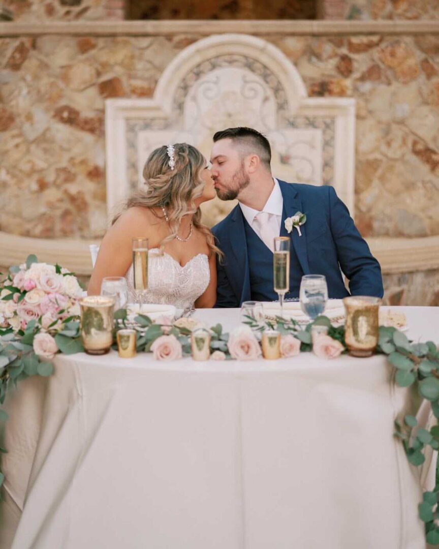 A bride and groom kissing at the head table.