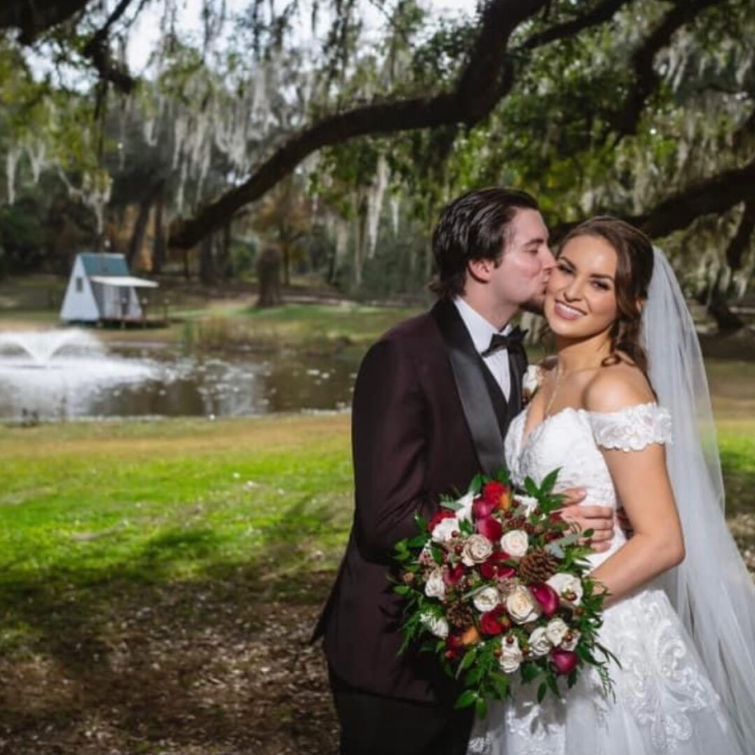 A Bride and Groom Standing by a Lake
