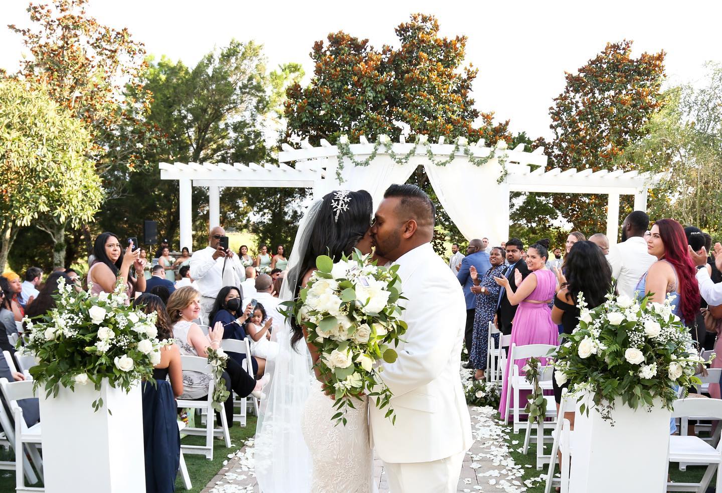 A Bride and Groom Kissing in Front of Guests