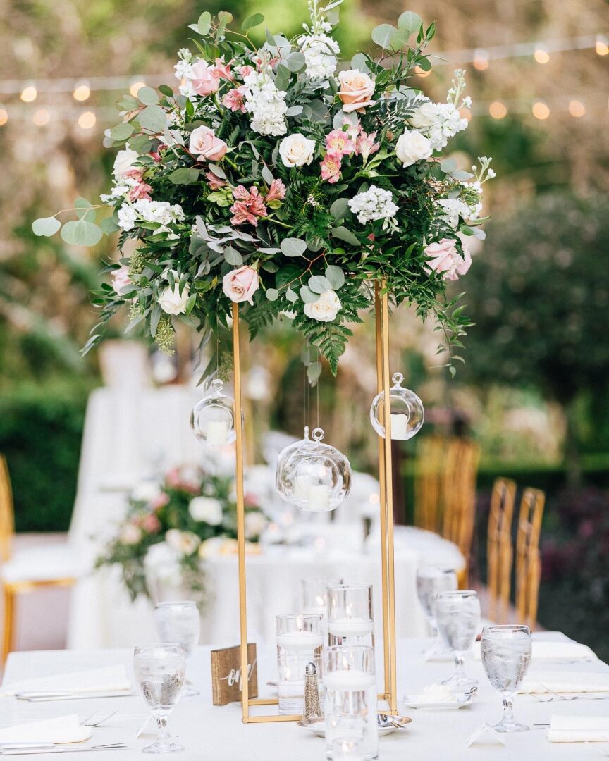 A table set with flowers and candles for an outdoor wedding.