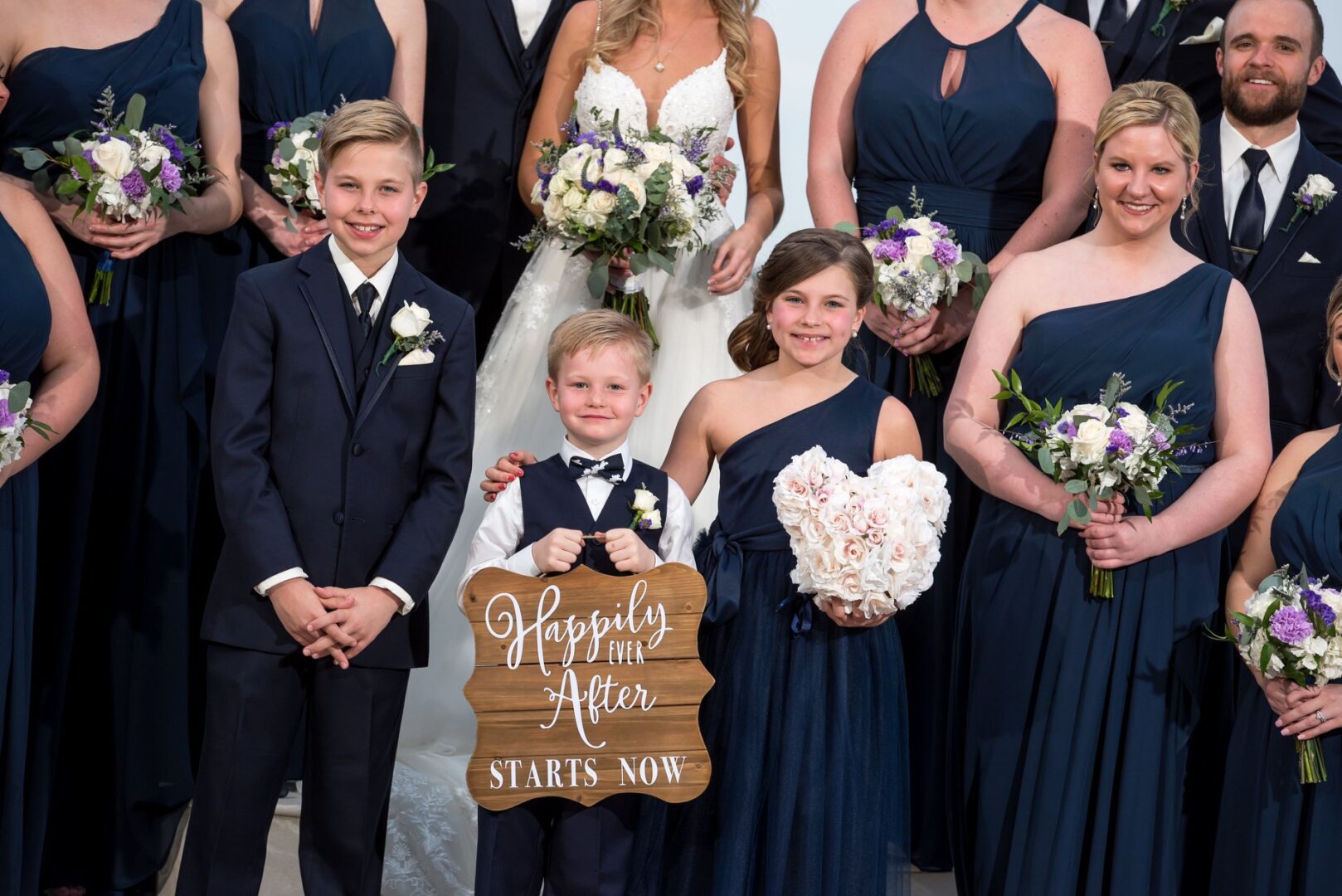 A group of people in suits and dresses holding flowers.