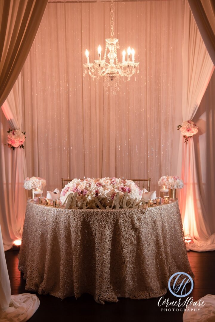 A Mr and Mrs Table With Candle Chandelier in Dim Light
