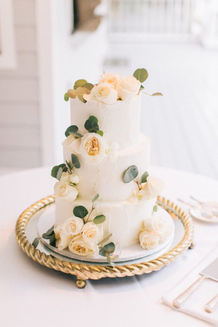 A Three Tiered Cake With White Roses