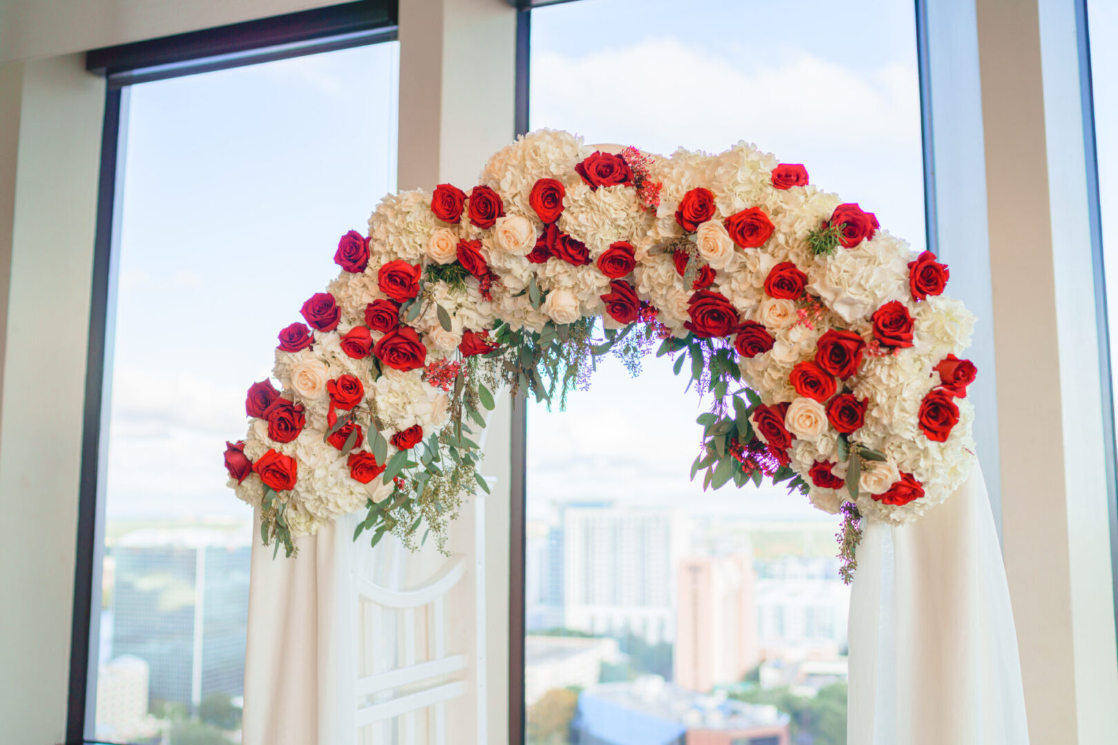 A Floral Arch With White and Red Roses