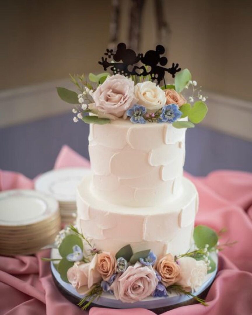 A two layer cake with flowers on top of it.