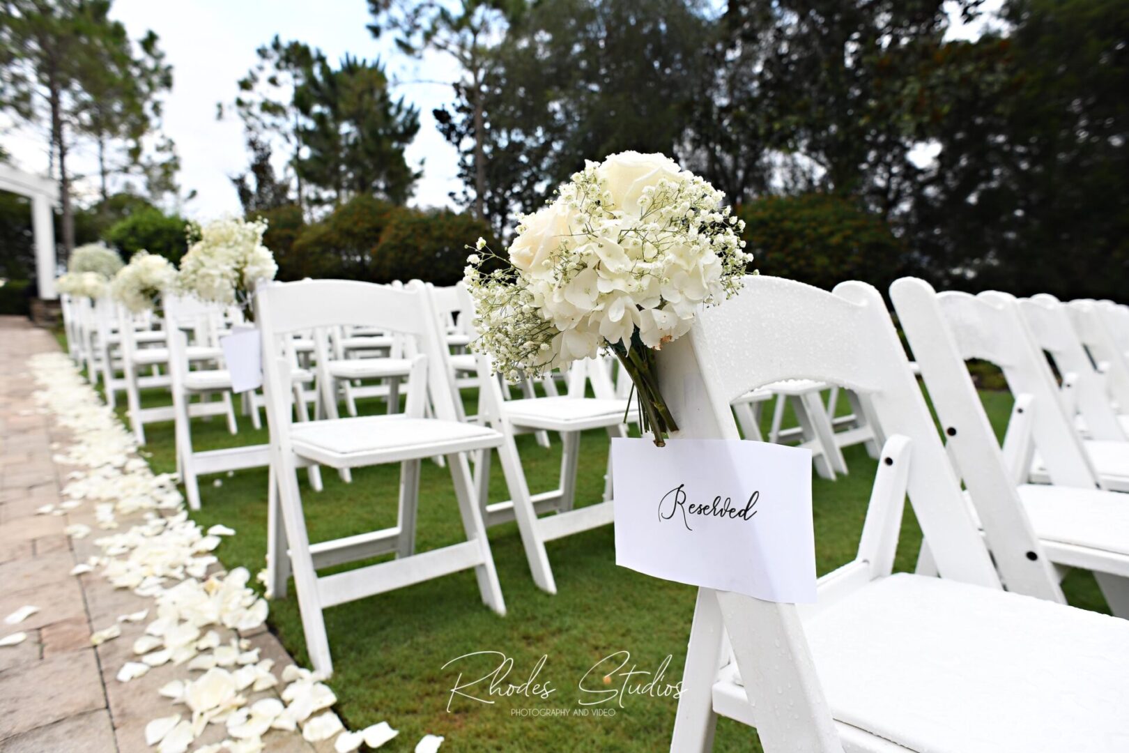 White Chairs With a Bunch of White Flowers
