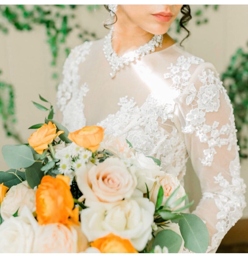 A bride holding her bouquet of flowers in front of the camera.