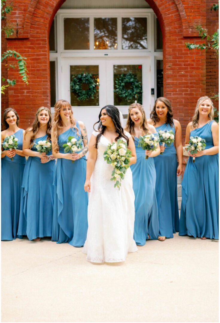 A bride and her bridesmaids in blue dresses.