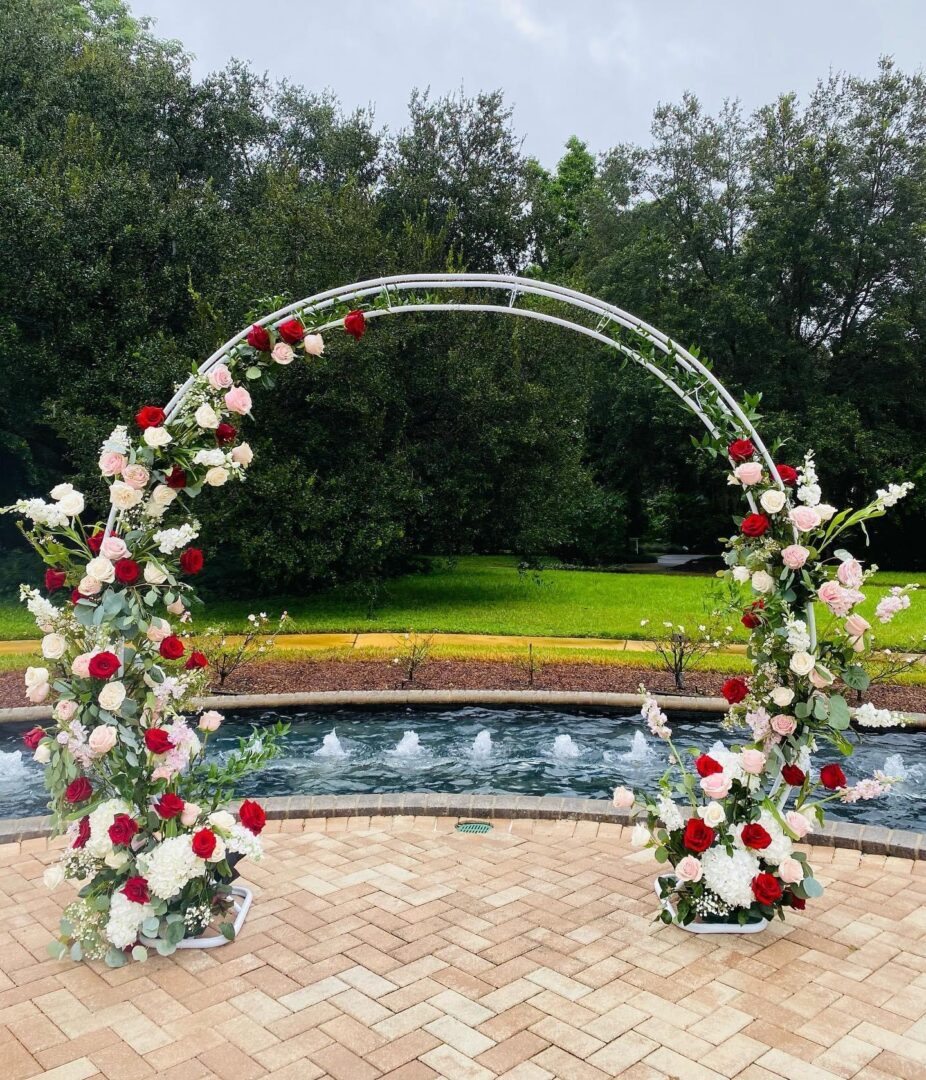 A wedding arch with red and white flowers.